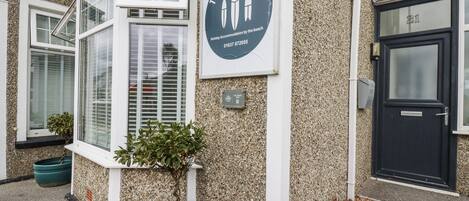 A building with a sign that reads "The Three Tees" and a contact number.