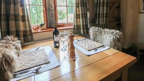 A dining table with placemats, a bottle of wine, and salt and pepper shakers. - Green Farm Cottage (Ashbourne)