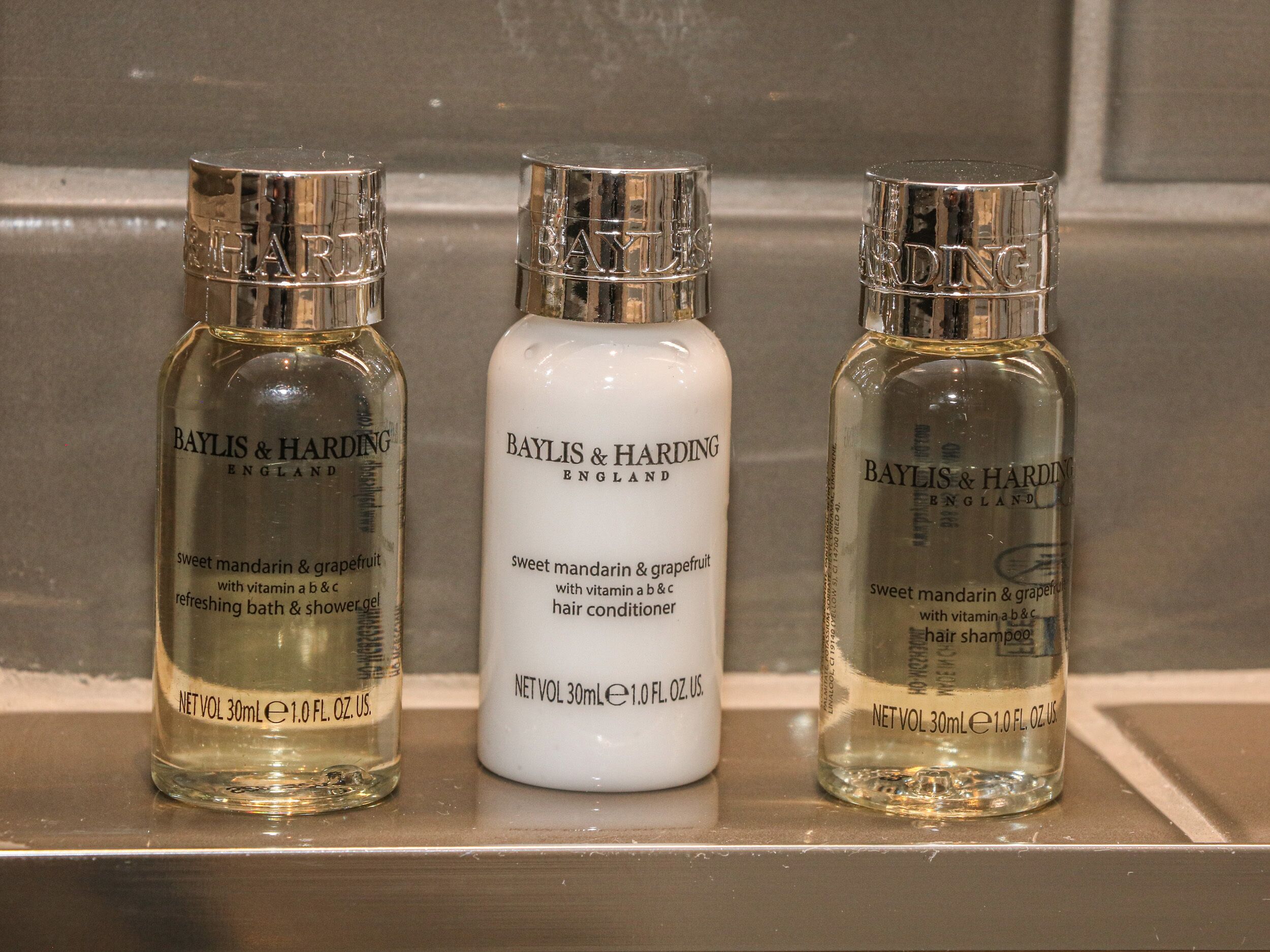 Three bottles of Baylis & Harding products on a shelf.