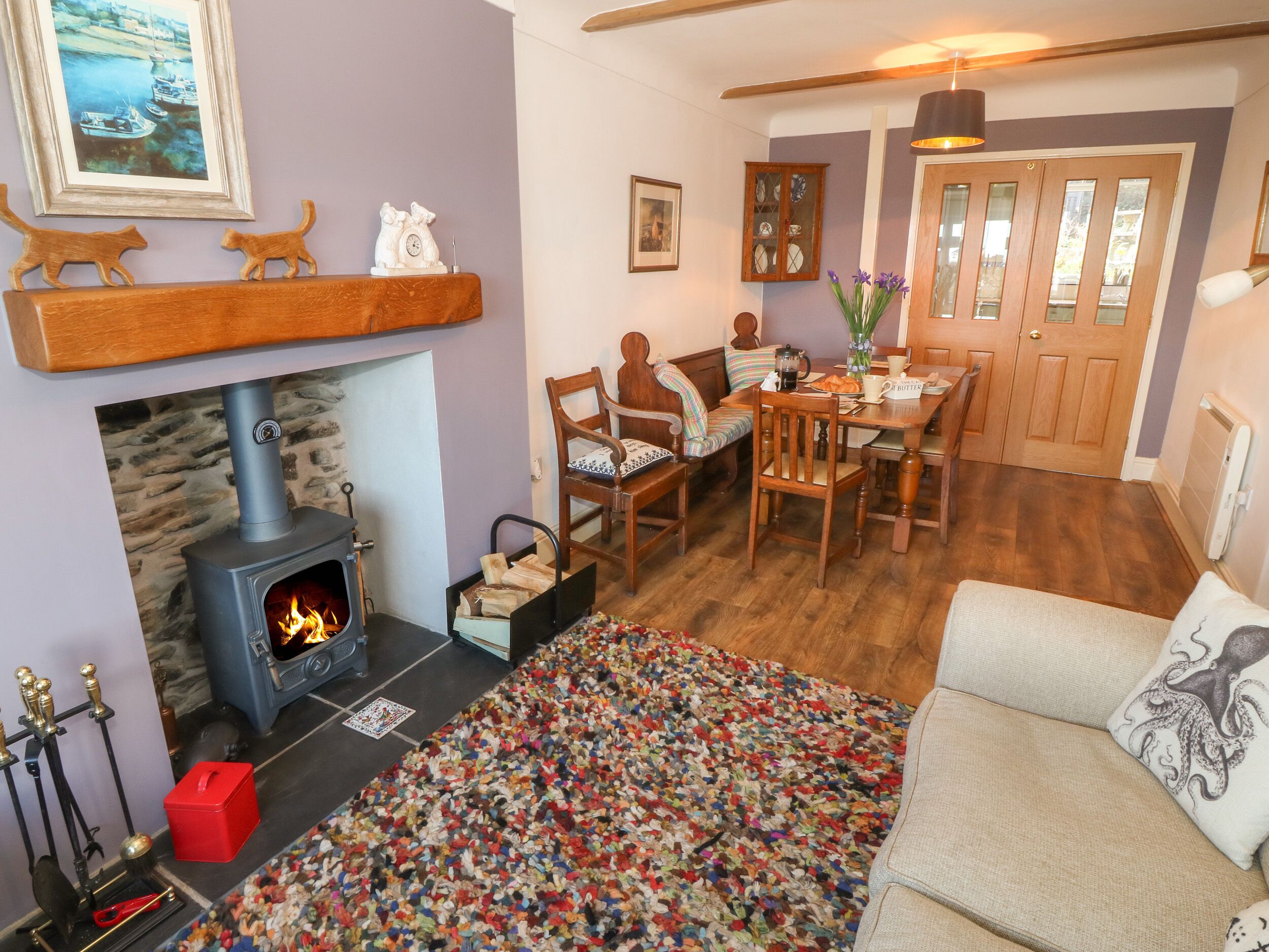 Una sala de estar acogedora con chimenea, muebles de madera y una alfombra colorida.