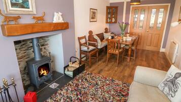 Una sala de estar acogedora con chimenea, muebles de madera y una alfombra colorida.