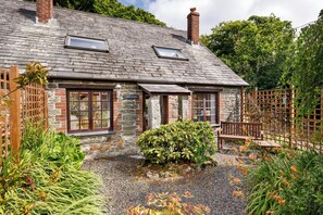 A stone house with a gravel driveway and a wooden fence. - Little Leighs (Launceston)