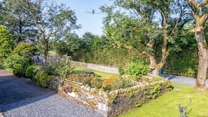 A stone wall with a sign indicating 'Woodside Barn Parking'.