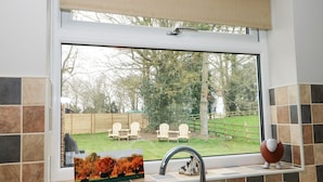A kitchen with a window overlooking a backyard.