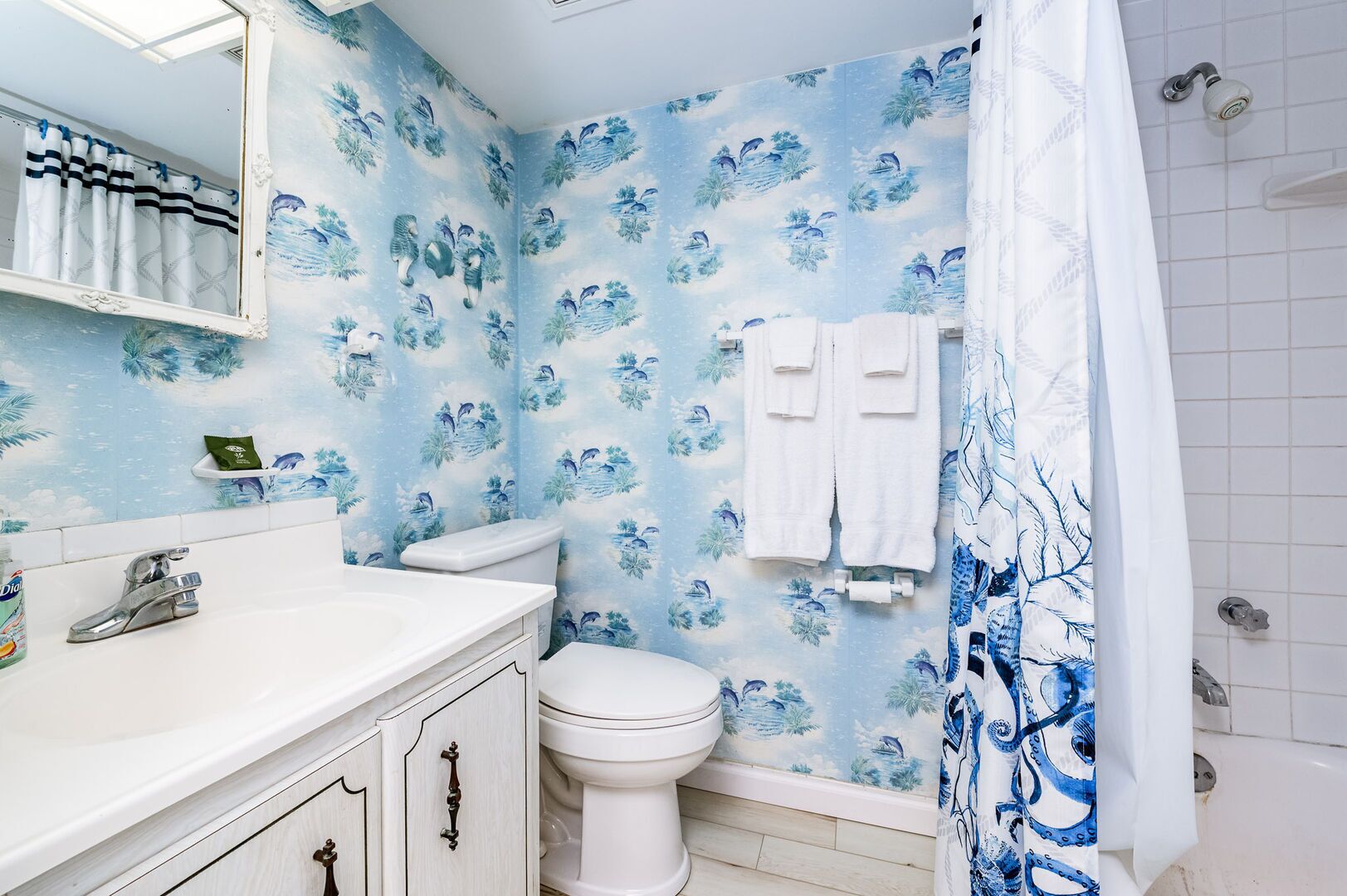 Une salle de bain équipée de toilettes, d’un lavabo et d’un rideau de douche.