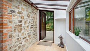 Un mur de pierre avec une porte en bois donnant sur un jardin.