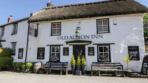 Eksteriørbillede af Old Albion Inn, med en traditionel hvid facade, sorte vinduesrammer og et stråtækt tag.