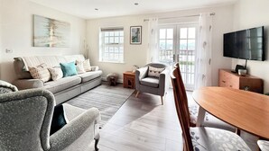 Un salon avec un canapé, un fauteuil et une table à manger.