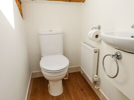 Un baño pequeño y limpio con un inodoro blanco, un lavabo blanco y un radiador.