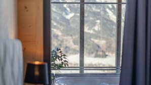 Ein Schlafzimmer mit einem großen Fenster und Blick auf schneebedeckte Berge.