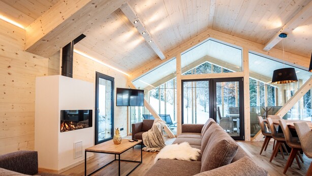 A modern interior with a fireplace, wooden walls, and a cozy seating area.