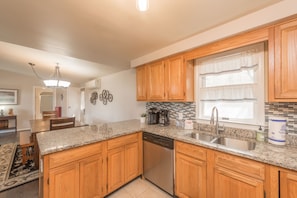 Enjoy cooking in this well-equipped kitchen with a dishwasher, sink, and window overlooking the dining area.