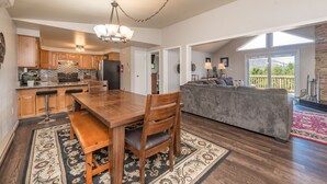 A spacious kitchen with wooden cabinets, a granite countertop, and a dining area with a wooden table and chairs.