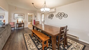 A dining area with a wooden table, benches, and a chandelier.