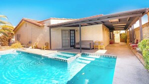A backyard with a swimming pool, patio furniture, and a covered seating area. - Rare 4BR Beauty with Pool 7 min to Strip! (Las Vegas)