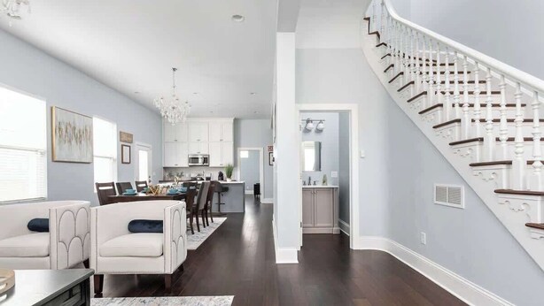 A spacious living area with a dining table, two sofas, and a staircase. - Brand New! Two Indy Homes Perfect for Groups! (Indianapolis)