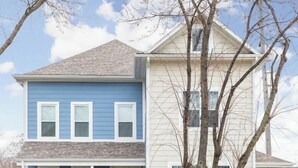 A two-story house with a front porch and a tree in front. - Brand New! Two Indy Homes Perfect for Groups! (Indianapolis)