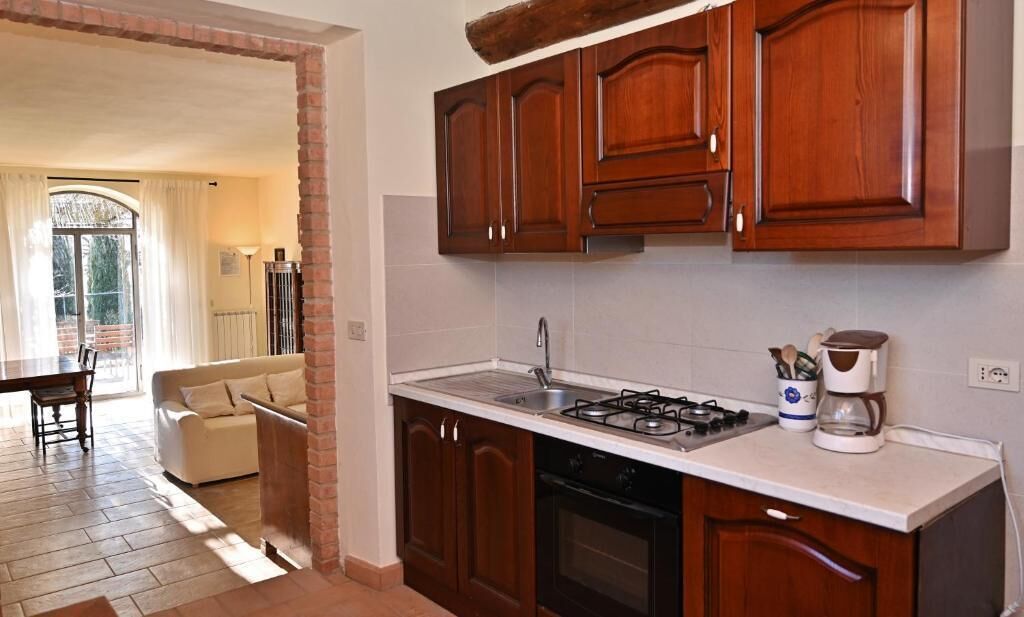A kitchen with wooden cabinets, a gas stove, and a coffee maker.