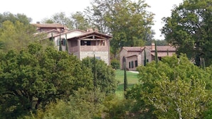 Une maison en pierre dotée d’un balcon et d’une petite dépendance attenante.