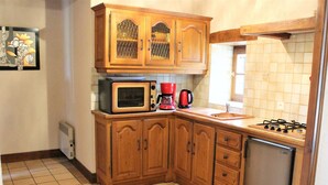 A kitchen with wooden cabinets, a microwave, a red coffee maker, and a gas stove. - House in Dordogne Valley, pets allowed (Cénac-et-Saint-Julien)