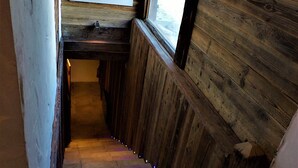 A narrow wooden staircase with a window at the top.
