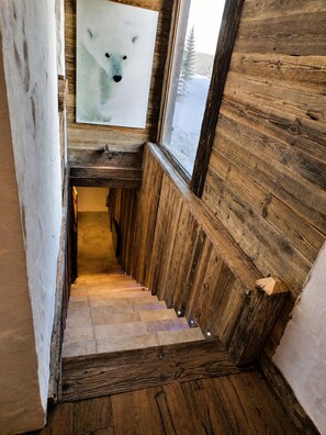 A wooden staircase leading to a lower level, with a window on the right side.