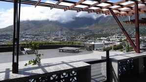 Een dakterras met uitzicht op een stadslandschap en bergen.