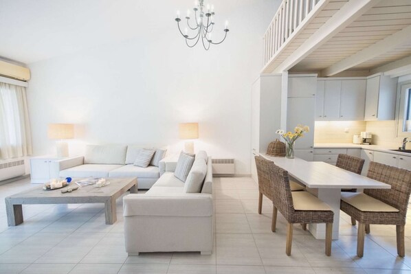 Relax in this spacious living area with a sofa set, armchair, and dining table, perfect for socializing and unwinding.