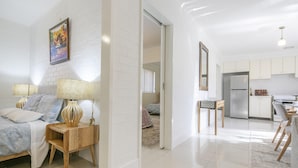 A modern apartment with a bedroom, living area, and kitchen.