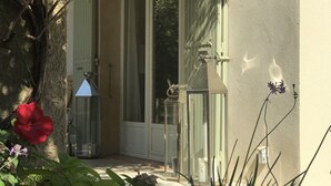 Et hus med en overdækket veranda, en dør og et vindue.