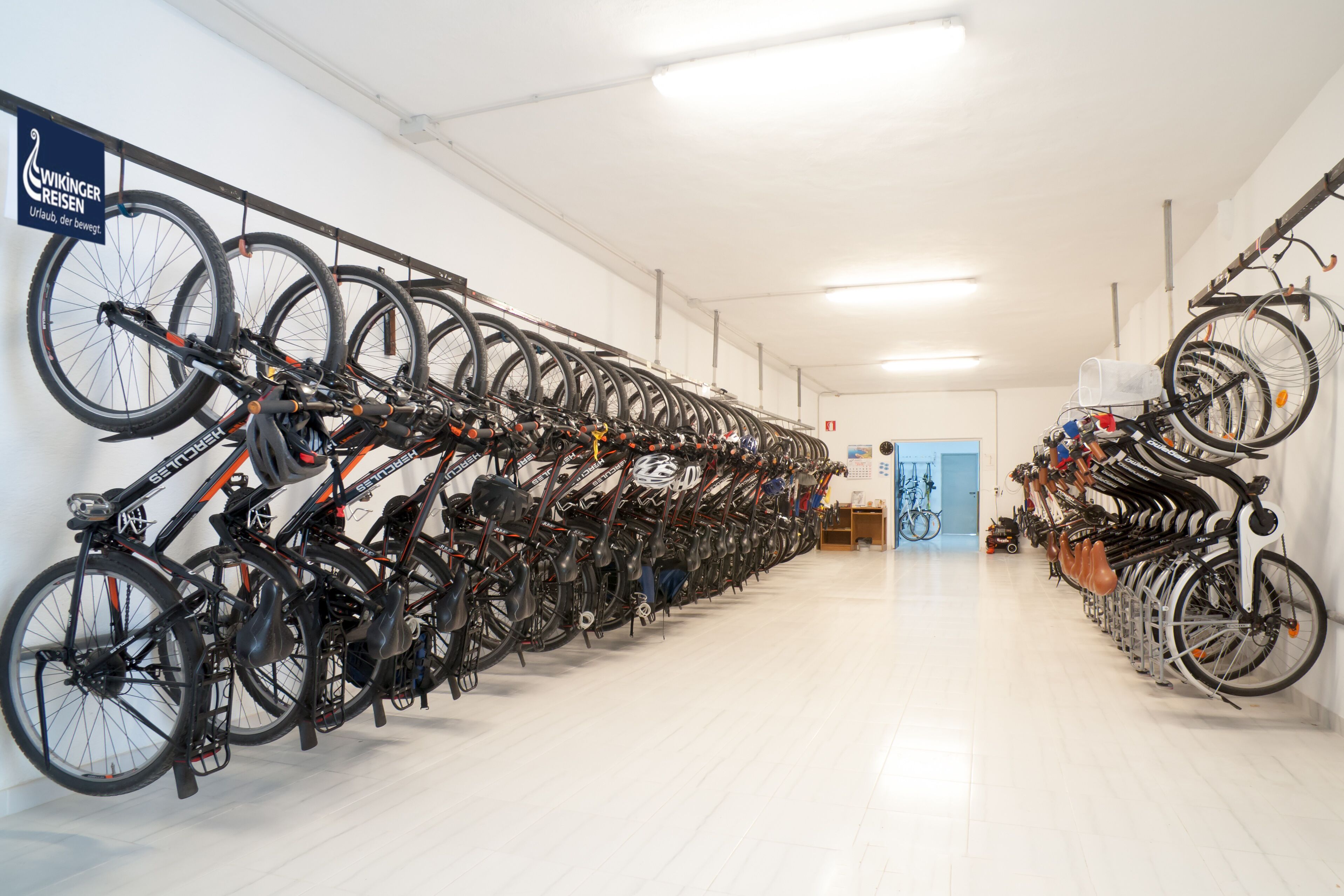 Zona de guardado para bicicletas con varias unidades aseguradas en soportes.