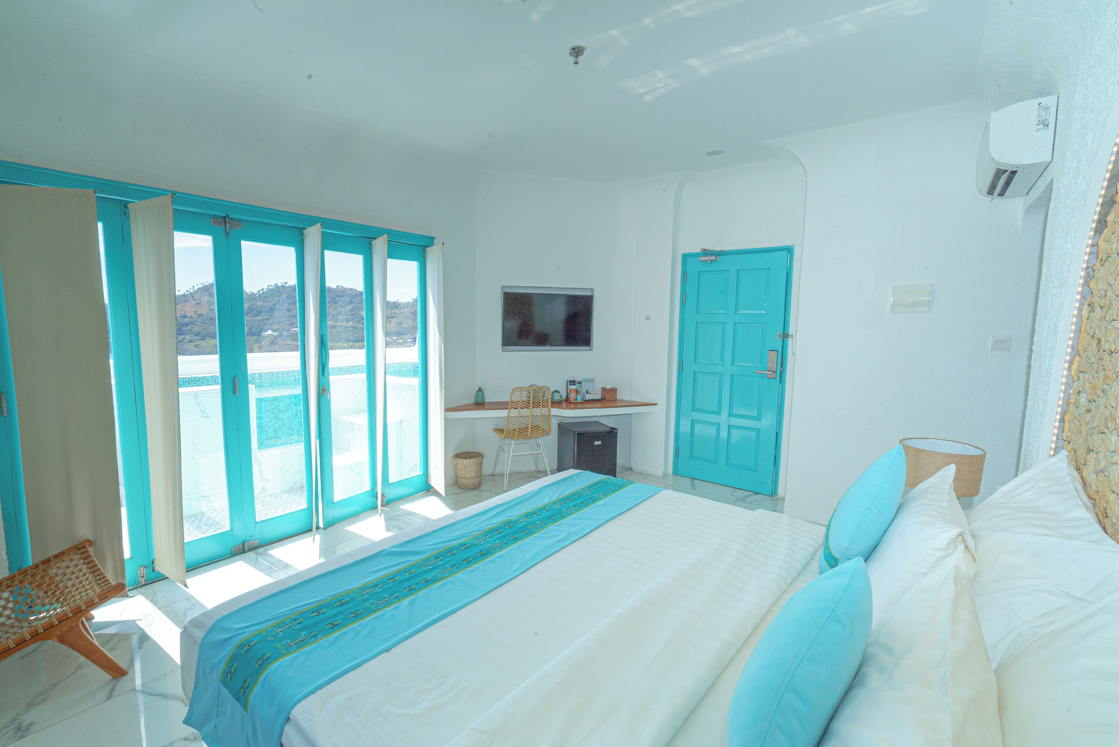 A bedroom with a bed, a desk, and a chair.