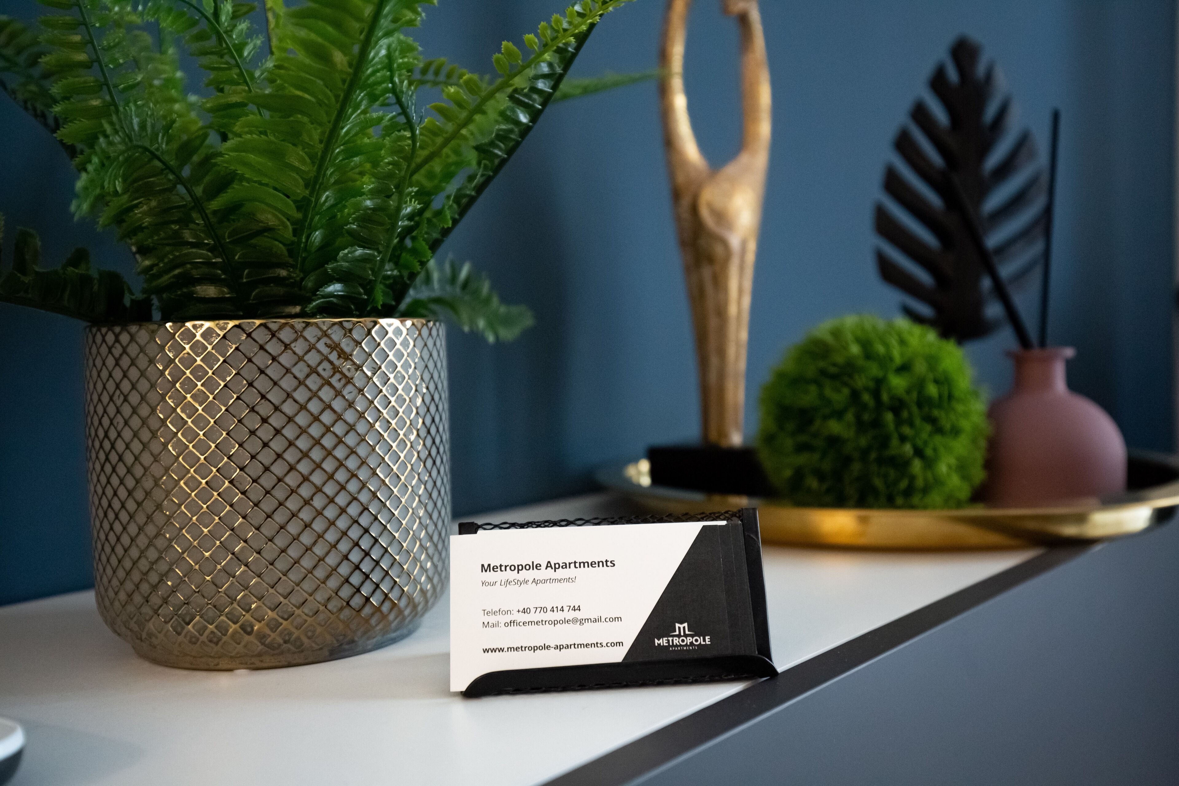 Carte de visite de Metropole Apartments, indiquant les coordonnées et l’adresse du site web.
