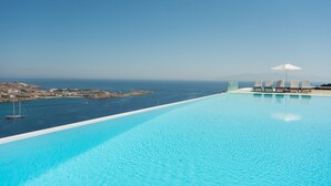 En klar, blå pool med havudsigt og fjerne kystlinjer.