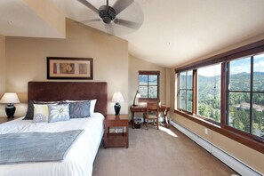 A bedroom with a bed, bedside tables, a desk, and a chair. There is a window with a mountain view. - Penthouse in Purgatory Lodge - Ski in/Out - Awesome Deck and Views (Durango)