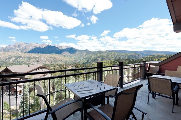 A balcony with a table and chairs, overlooking a mountainous landscape. - Penthouse in Purgatory Lodge - Ski in/Out - Awesome Deck and Views (Durango)