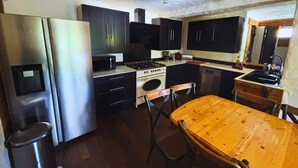 Une cuisine compacte équipée d’un réfrigérateur, d’une cuisinière, d’un four à micro-ondes et de placards.