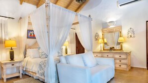 Une chambre à coucher avec un lit à baldaquin, des lampes de chevet, une commode et un miroir.
