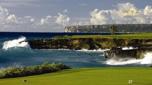 A golf course with a view of the ocean and cliffs. - Golden Bear Lodge and Spa (Punta Cana)