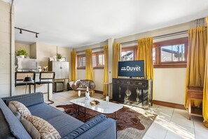 Een moderne woonkamer met een bank, een salontafel, een televisie en een eethoek met stoelen en een tafel.