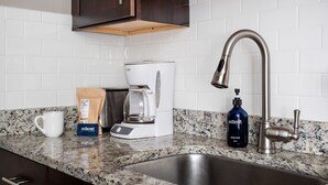 A kitchen with a coffee maker, a bottle of hand soap, and a mug on the counter. - 3 Blocks to King, Historic Home | The Garden Gates (Charleston)