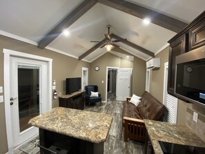 Cozy living space with a kitchen, seating area, and TV.