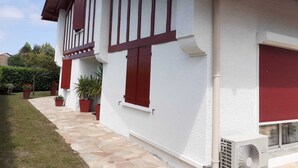 A white building with red window shutters and a stone pathway leading to the entrance. - Charming Basque house with jacuzzi, close to the ocean (Saint-Jean-de-Luz)