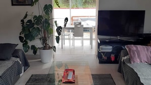 A living room with a glass coffee table, two sofas, a TV, and a large window. - Charming Basque house with jacuzzi, close to the ocean (Saint-Jean-de-Luz)