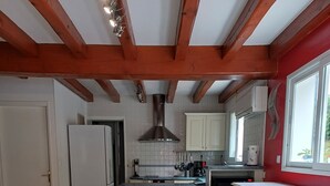 A kitchen with white cabinets, a stainless steel range hood, and a tiled floor. - Charming Basque house with jacuzzi, close to the ocean (Saint-Jean-de-Luz)