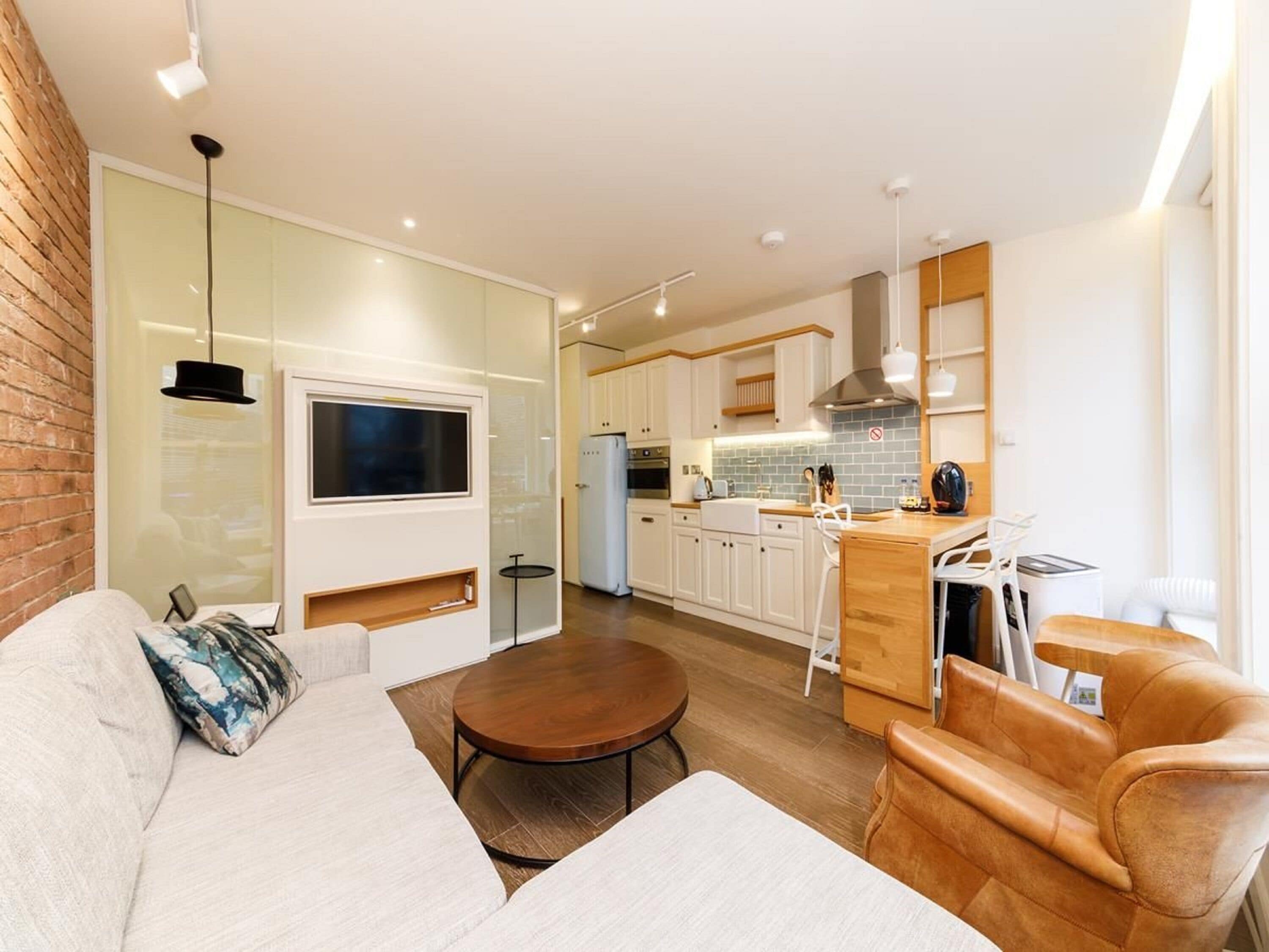 Un appartement moderne comprenant un salon, une cuisine et un coin repas.