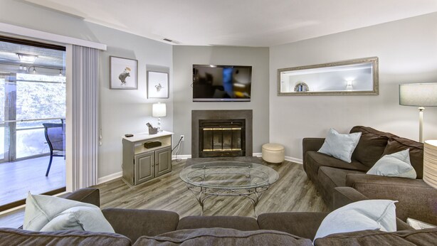 A modern living room with a fireplace, a flat-screen TV, and a glass coffee table. - Short breaks in September and October live now! (Rehoboth Beach)