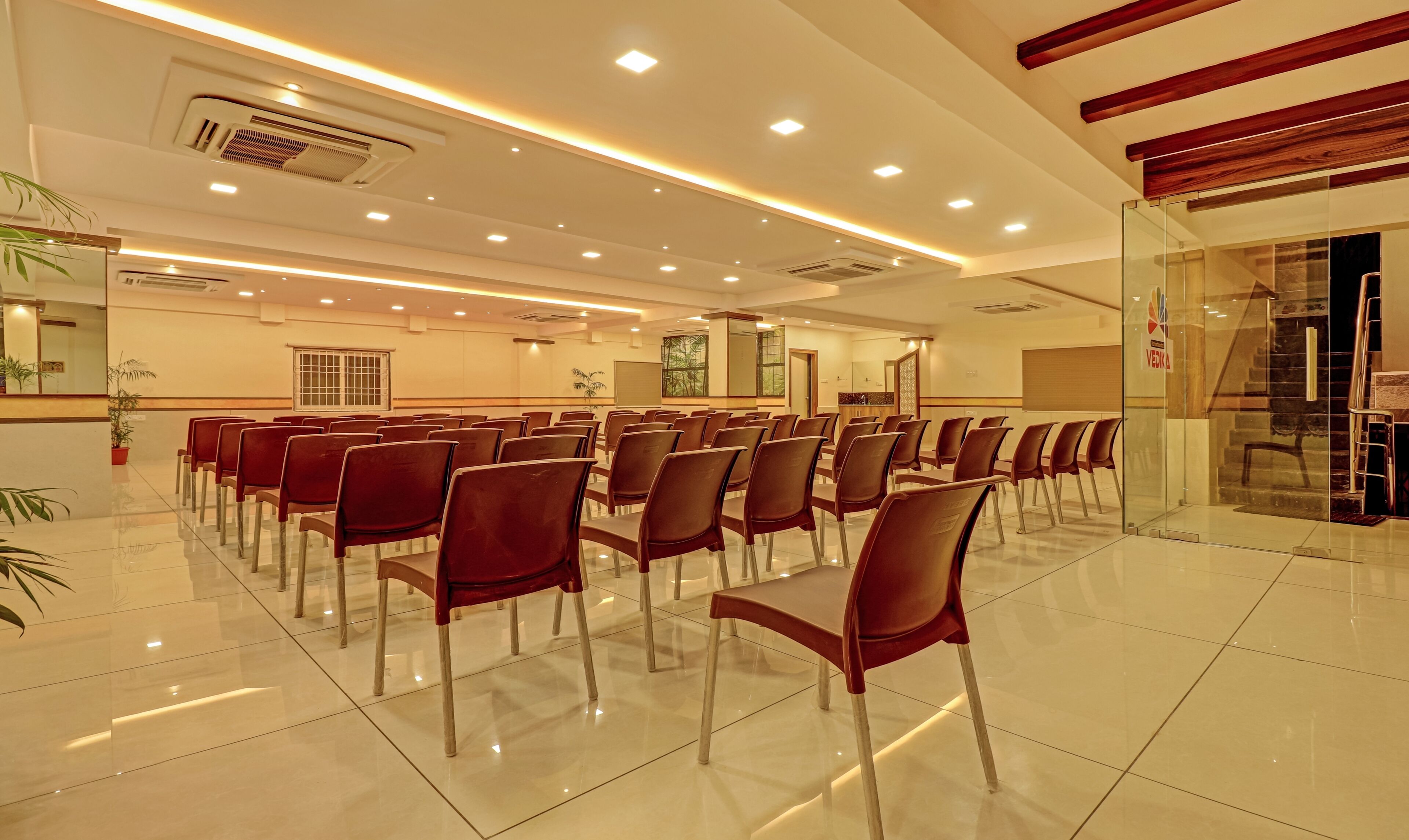 A conference room with rows of chairs, a podium, and a large window.