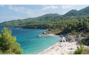 Una playa cerca, sillas reclinables de playa, toallas de playa