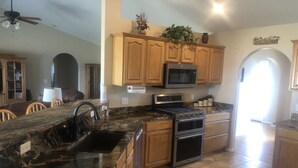 A kitchen with granite countertops, wooden cabinets, a stainless steel oven, and a microwave. - Country house in Montrose (Montrose)